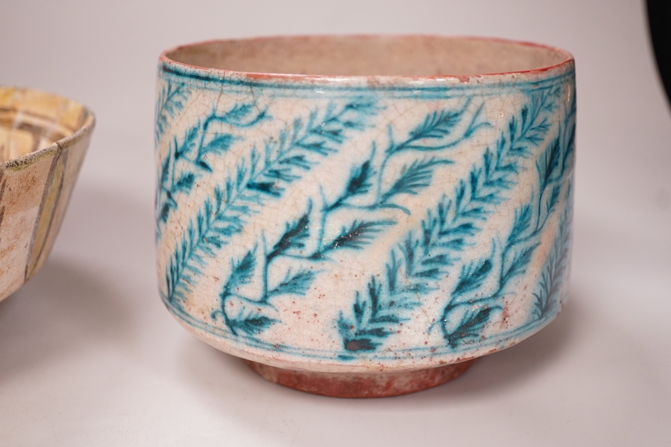 An Islamic Persian bowl with turquoise blue leaf design, 15cm diameter, together with a section of an Islamic tile, and another Islamic bowl, possibly Kashan. Tallest 11cm